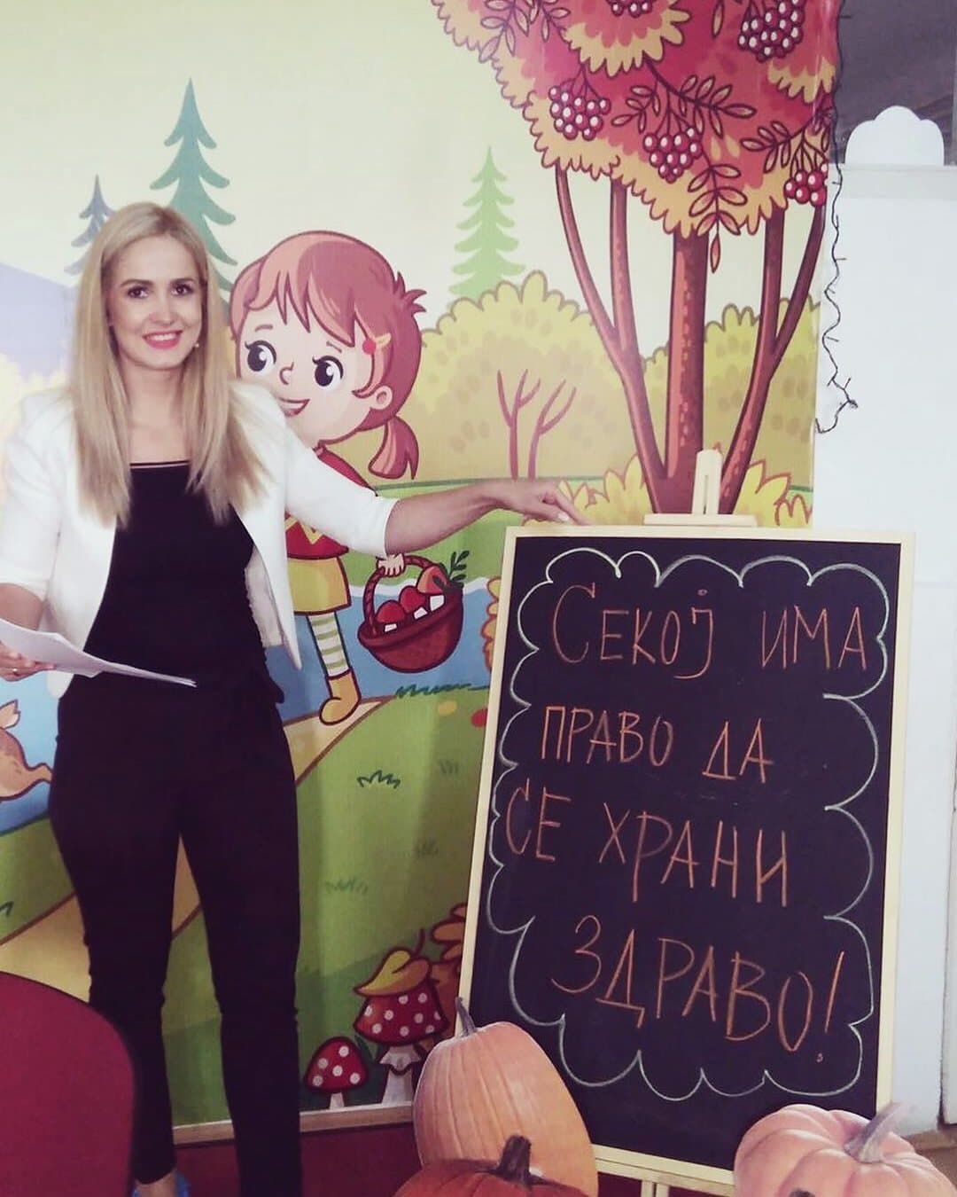 Фани Гулевска покрај табла со пораката „Секој има право да се храни здраво!“